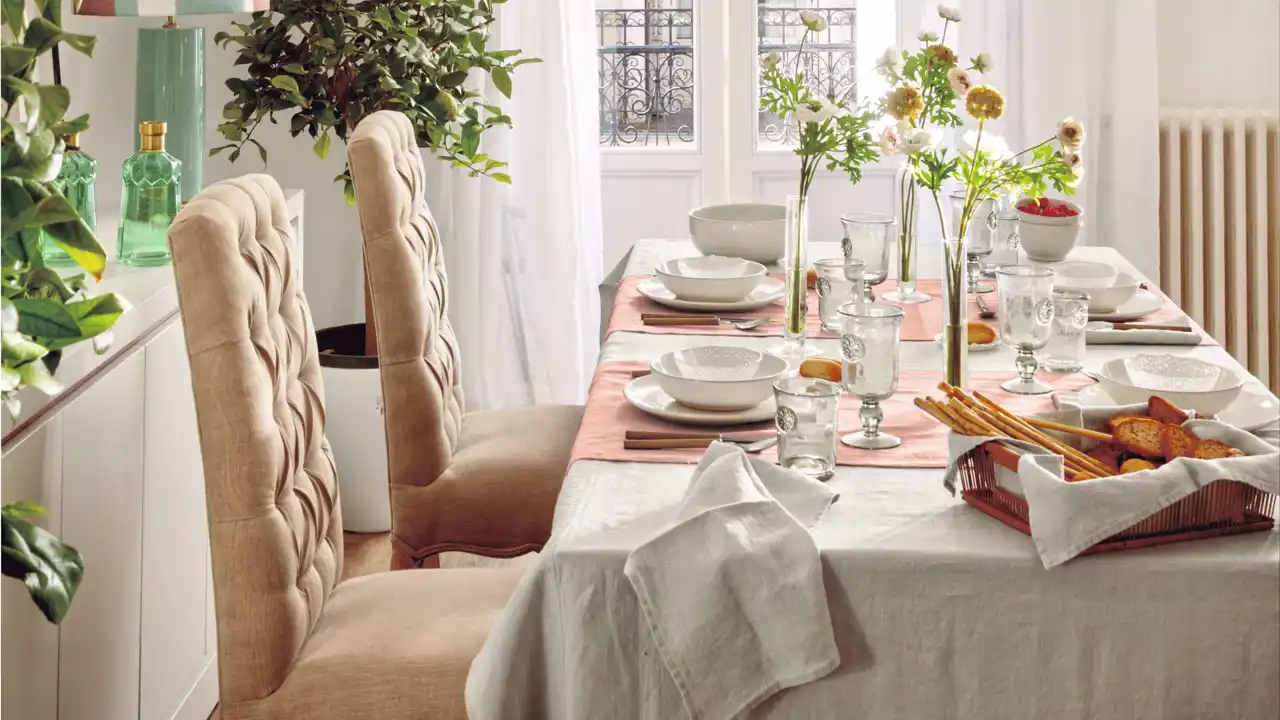 Comedor con sillas clásicas y mantel rosa