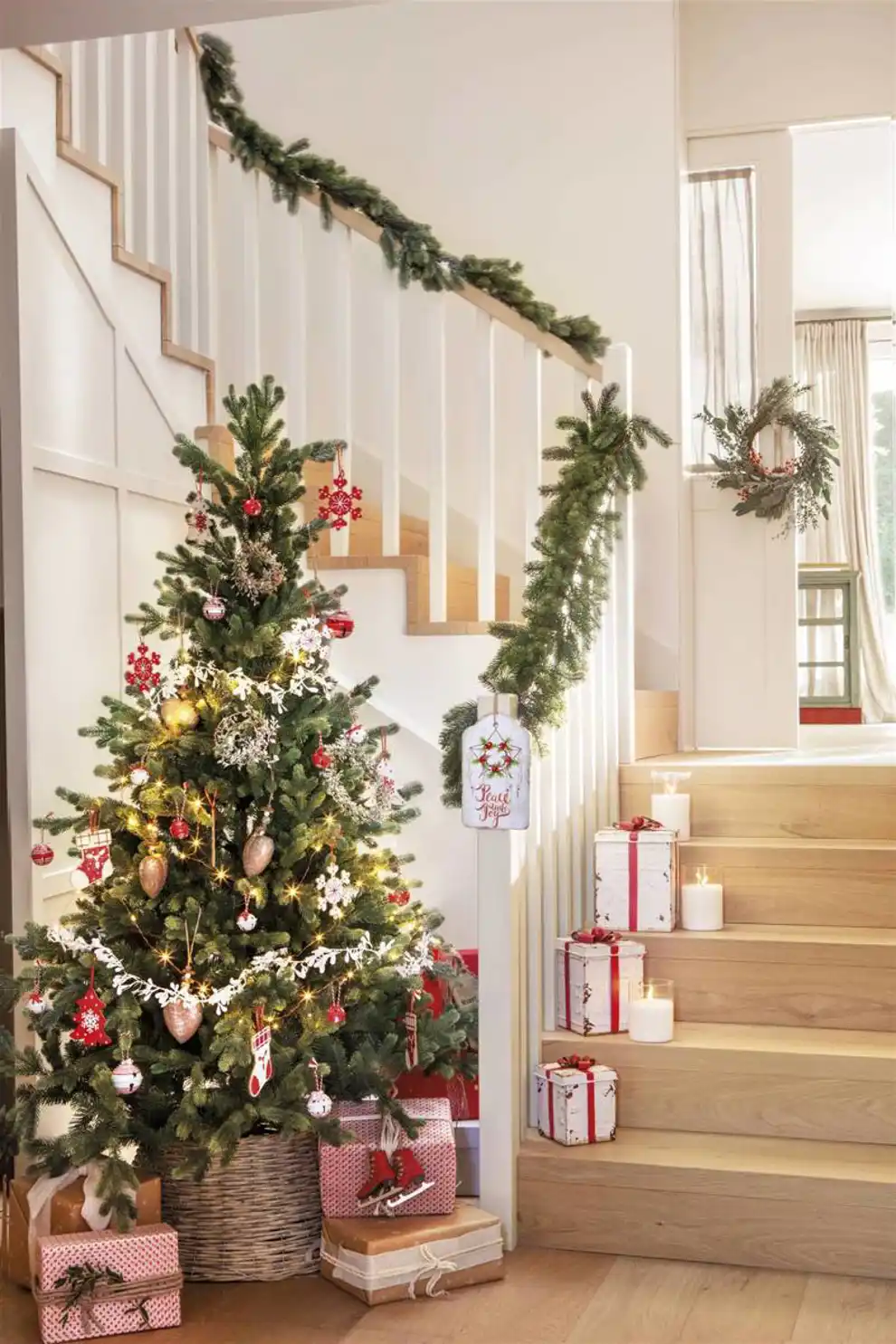 Escalera decorada por Navidad con regalos y velas en los escalones