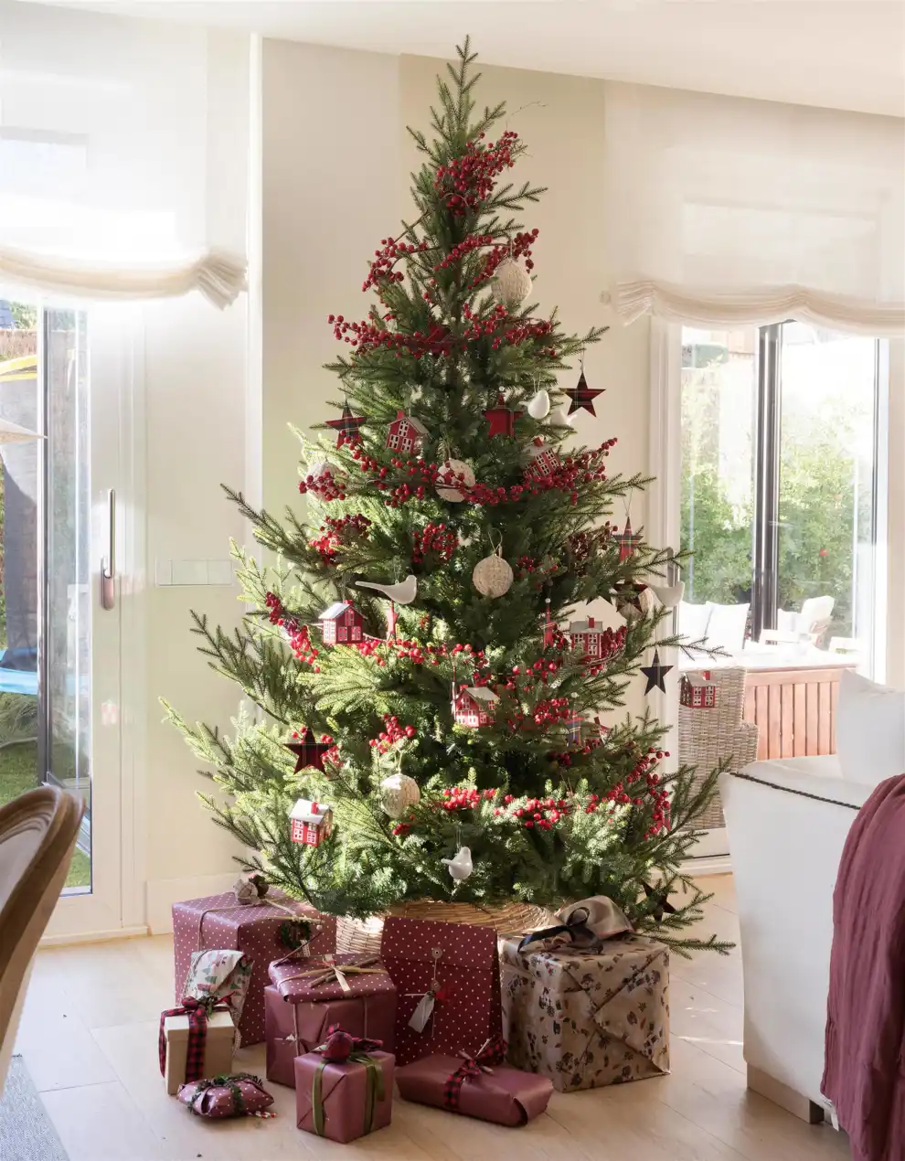 00529151 Árbol de Navidad con bodegón de regalos en tonos granates cubriendo su pie