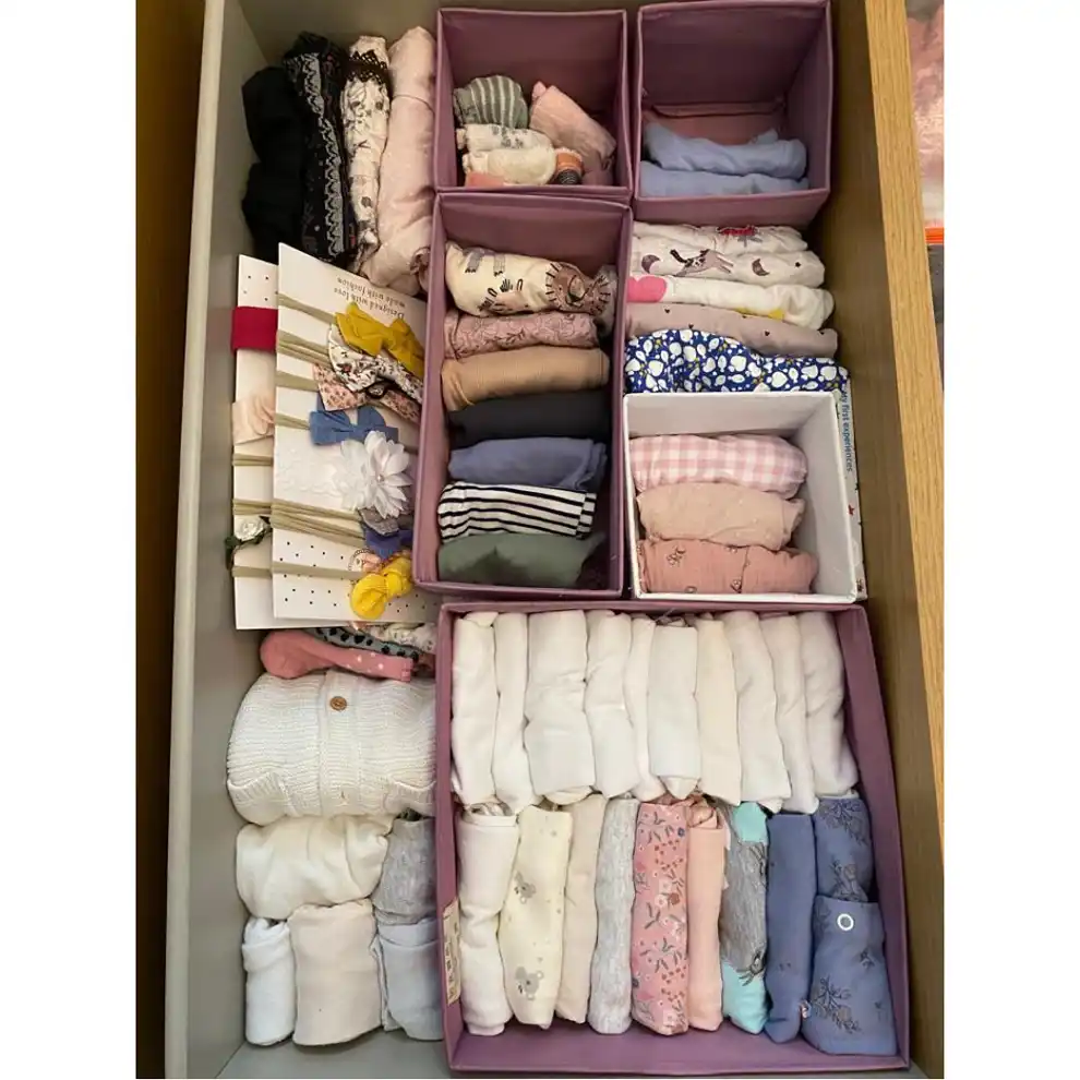 Un cajón con ropa de niña después de haber sido ordenado con el método KonMari