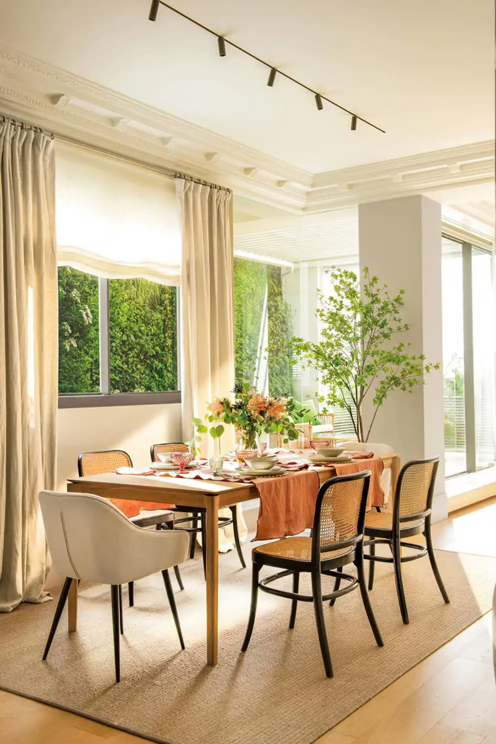 Comedor decorado con mesa de madera y sillas de diferentes estilos