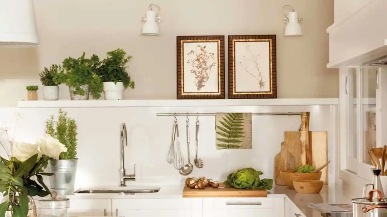 Cocina pequeña con muebles blancos y barra con ganchos en la zona de trabajo