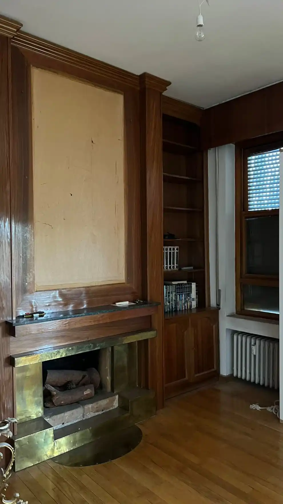 Antes: zona del salón con chimenea y revestimientos oscuros.