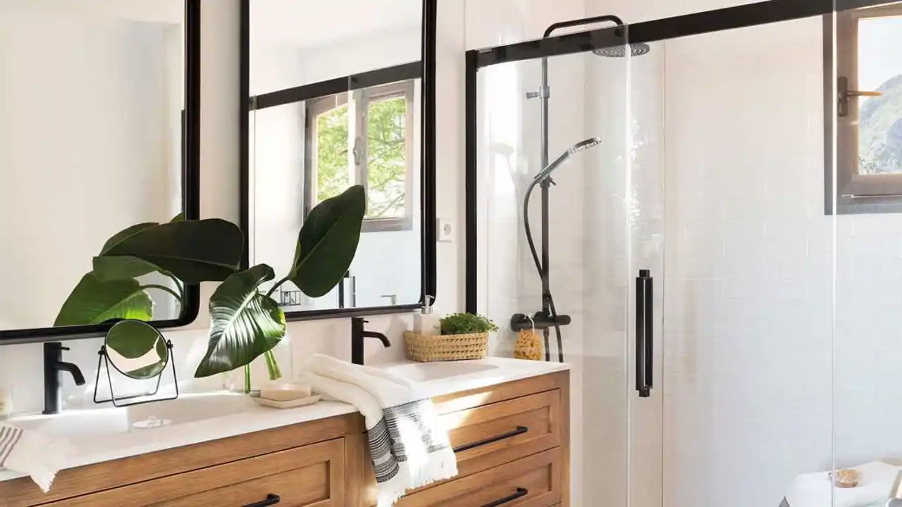 Baño con una gran ducha de pared a pared y detalles en negro