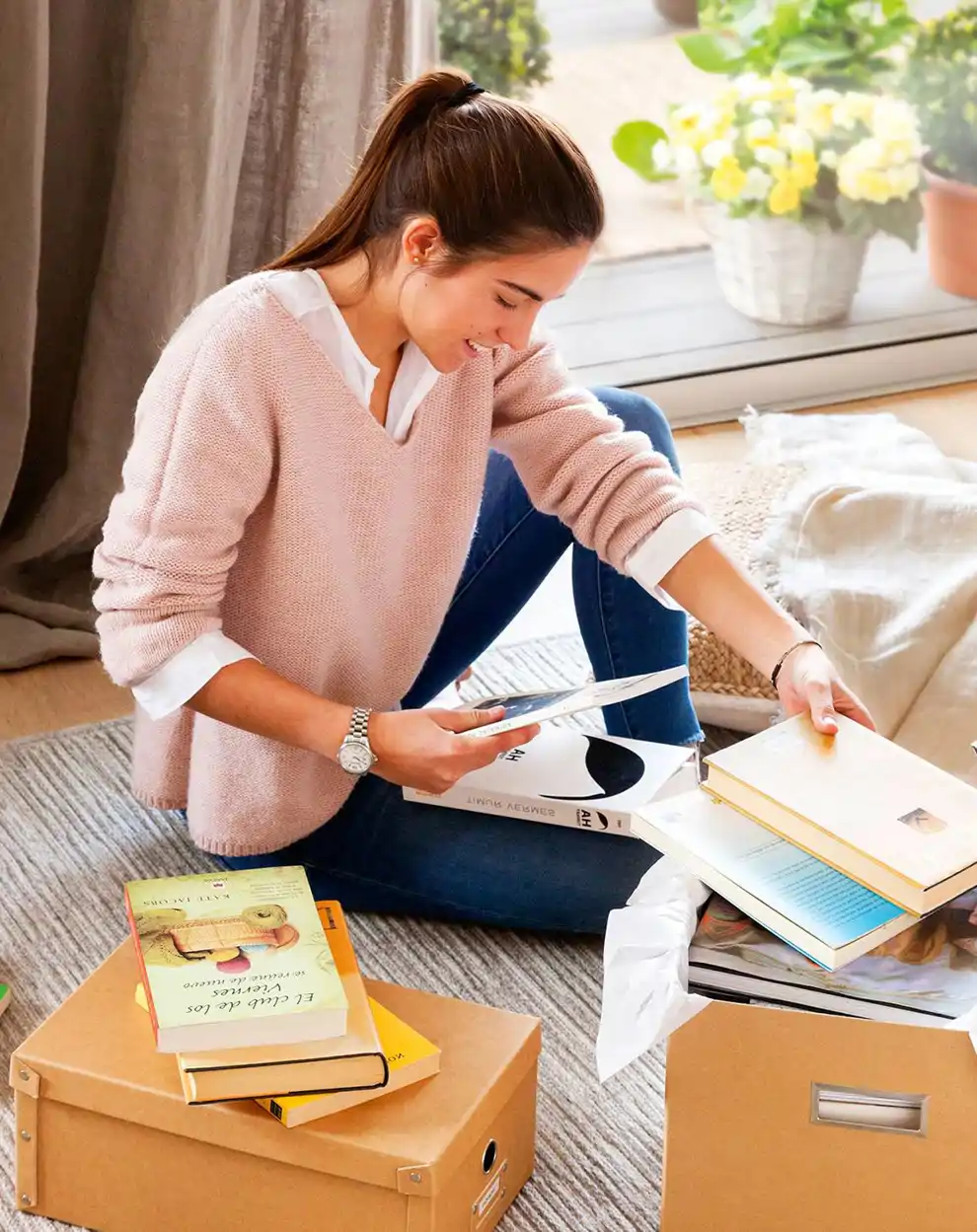 Mujer ordenando libros en cajas