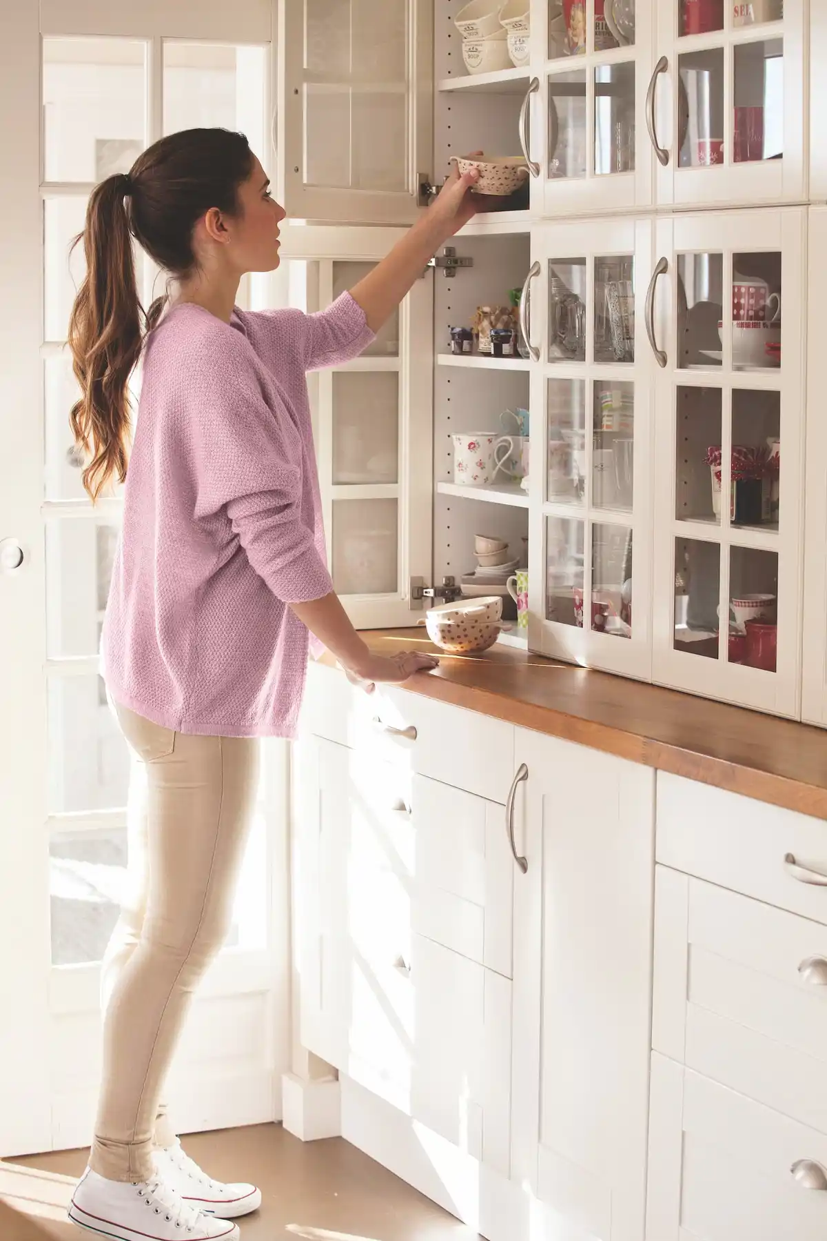 Mujer ordenando un armario de la cocina